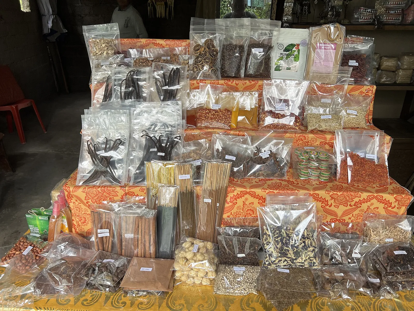 Bags of spices, cinnamon sticks, cloves and coffee on display at a shop in Munduk
