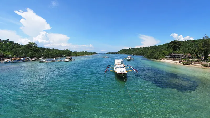 Turquoise channel between Nusa Lembongan and Nusa Ceningan with a moored boat and green shores