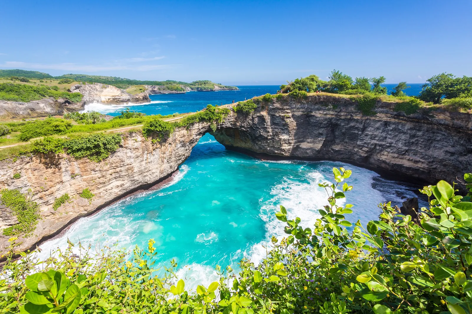 Broken Beach on Nusa Penida, a natural rock arch over a turquoise pool enclosed by cliffs