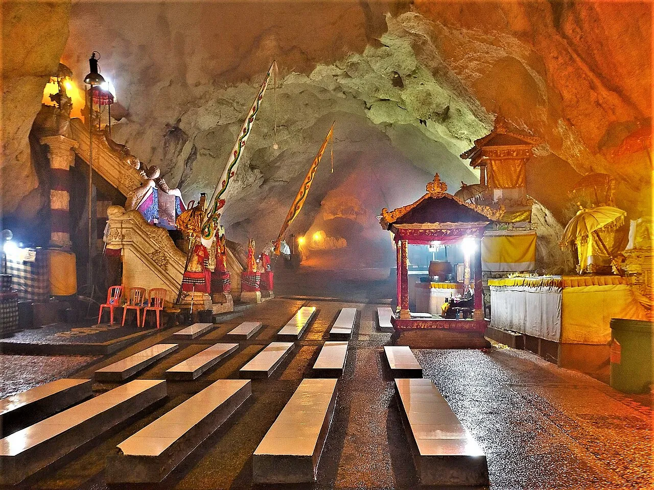 The shrines and benches inside the lit cave temple of Goa Giri Putri on Nusa Penida