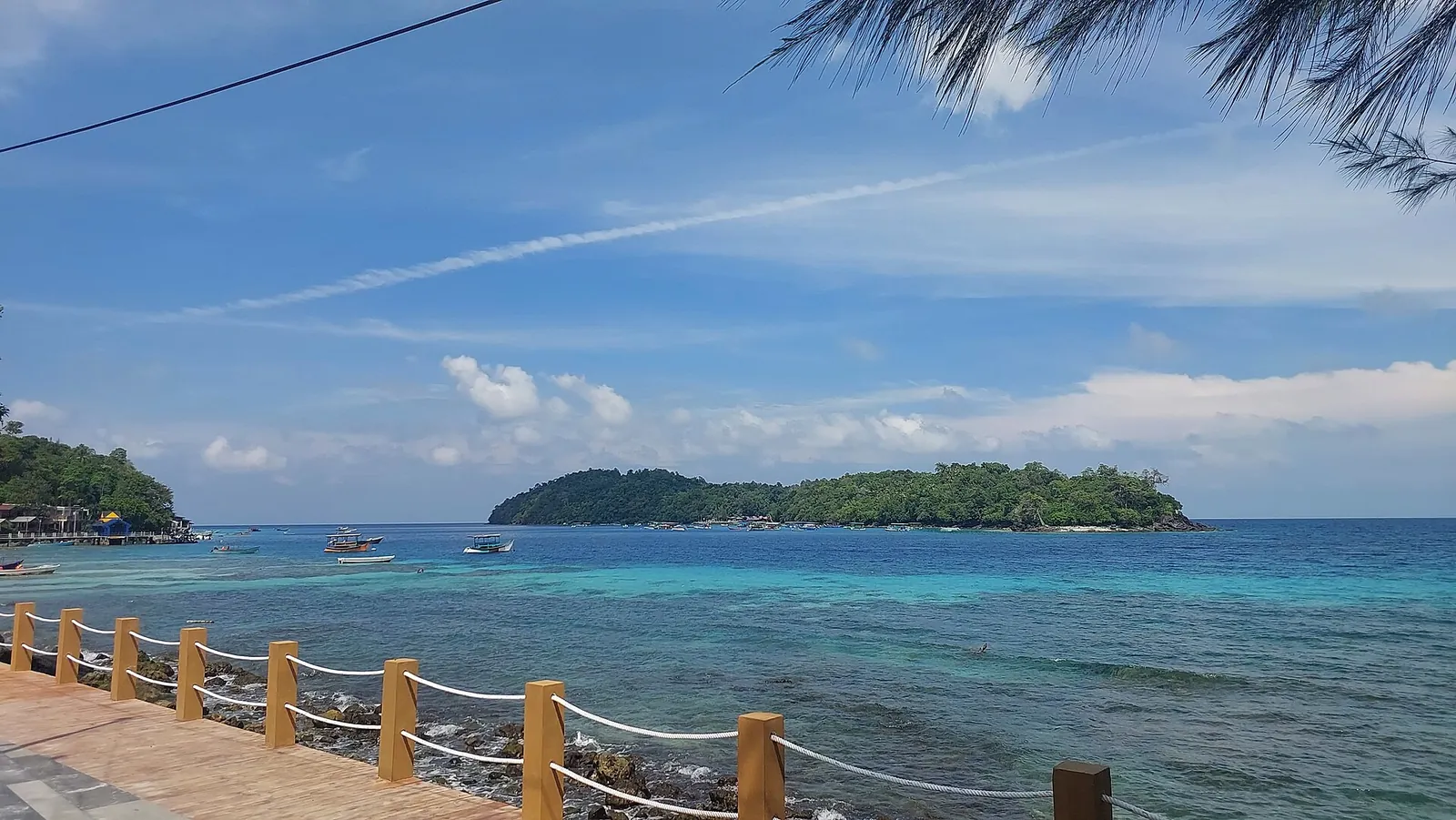 Rubiah island seen across the blue channel from the waterfront walkway at Iboih, Pulau Weh