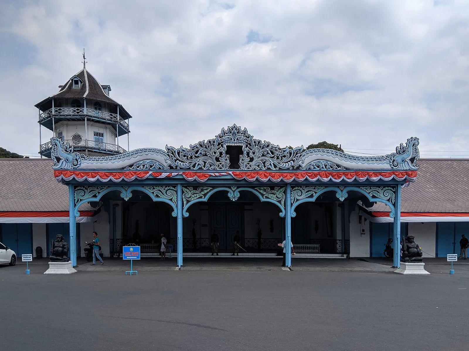 Blue and white carved gateway of the Keraton Surakarta Hadiningrat with the Sanggabuwana tower rising behind it