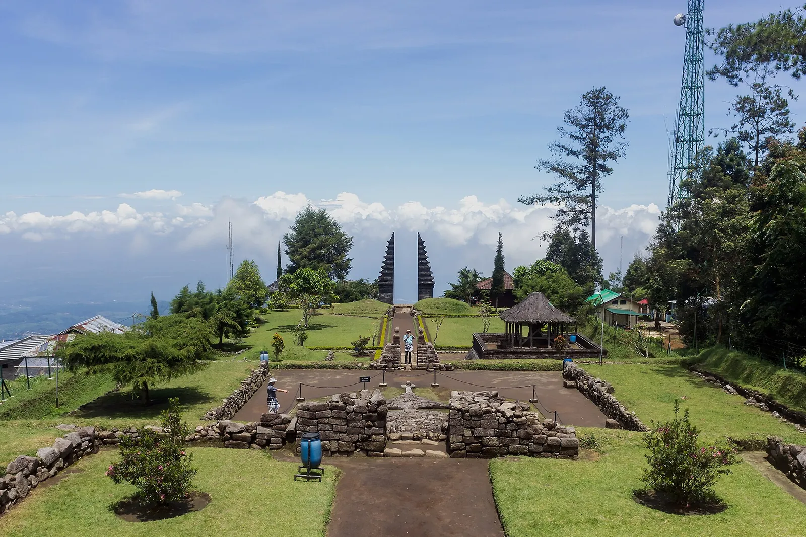 Grassy terraces and split gates of Candi Cetho on Mount Lawu, with hills and sky beyond