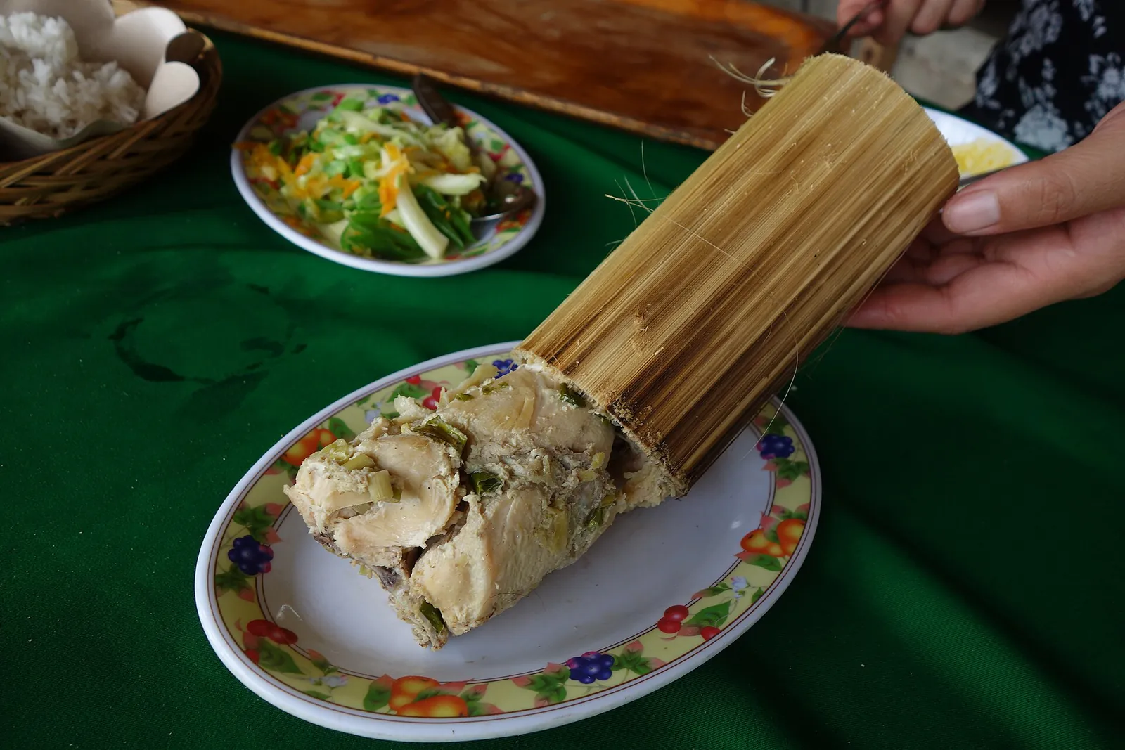 Chicken pa'piong cooked inside a bamboo tube, served on a plate in Toraja