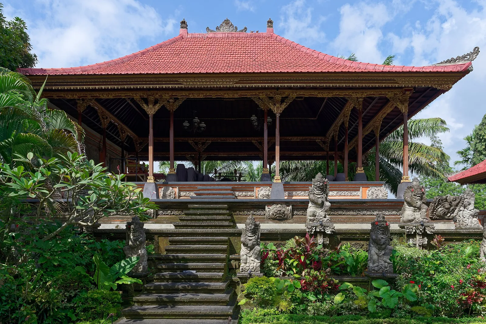 Open pavilion with a red tiled roof and carved stone steps inside Ubud Palace
