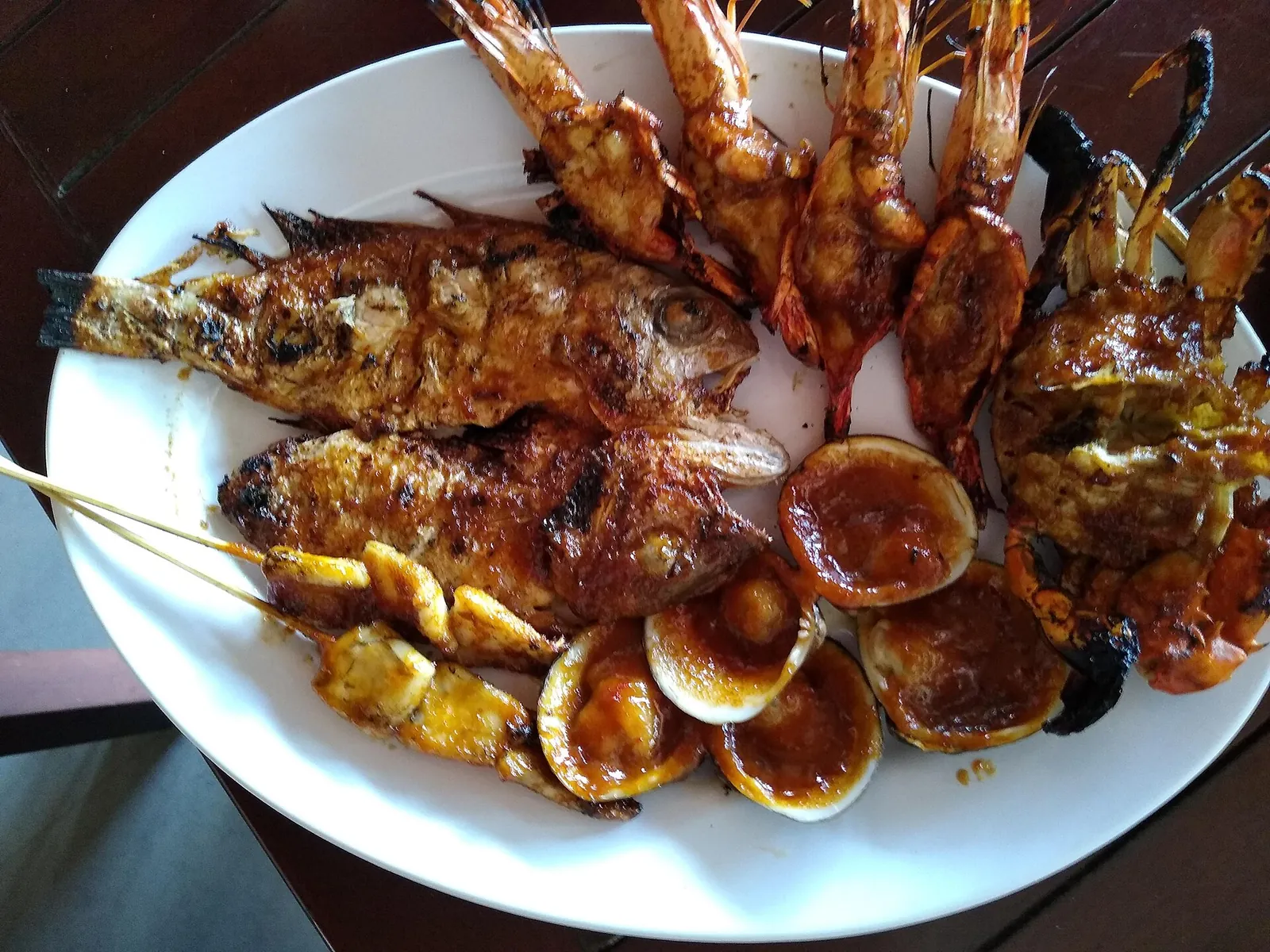 Plate of grilled fish, prawns, squid and clams from a beach restaurant in Jimbaran