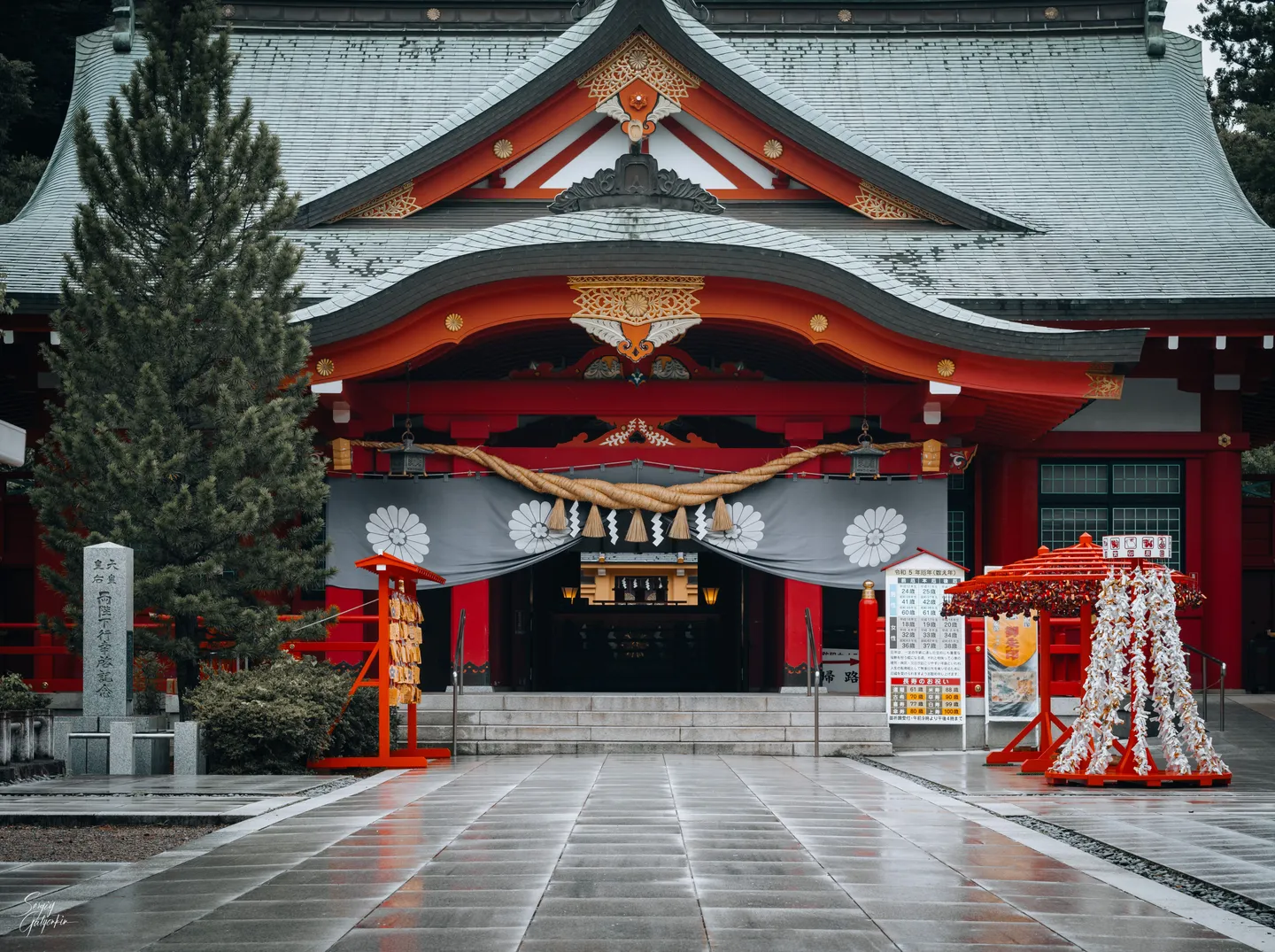 En japansk helgedom med röda detaljer en regnig dag.