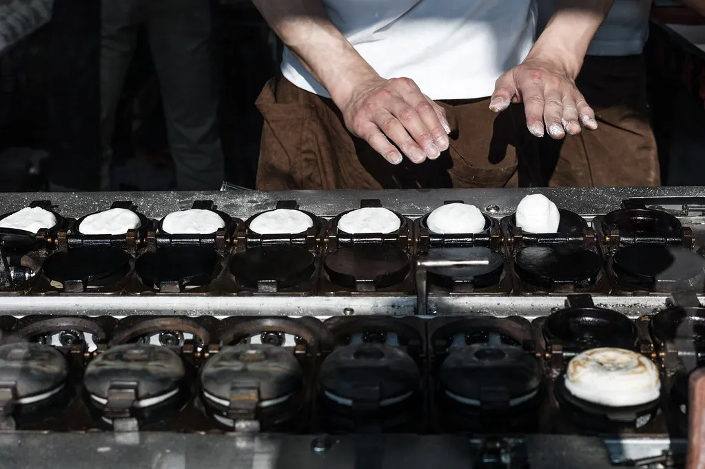 Umegae mochi che cucina su una piastra a Dazaifu.