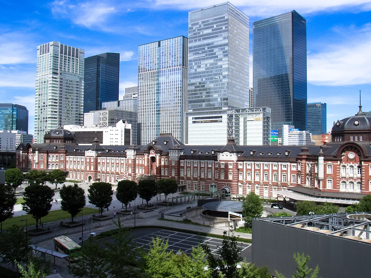 Tokyo Stations Marunouchi-fasad med moderna höghus i bakgrunden.