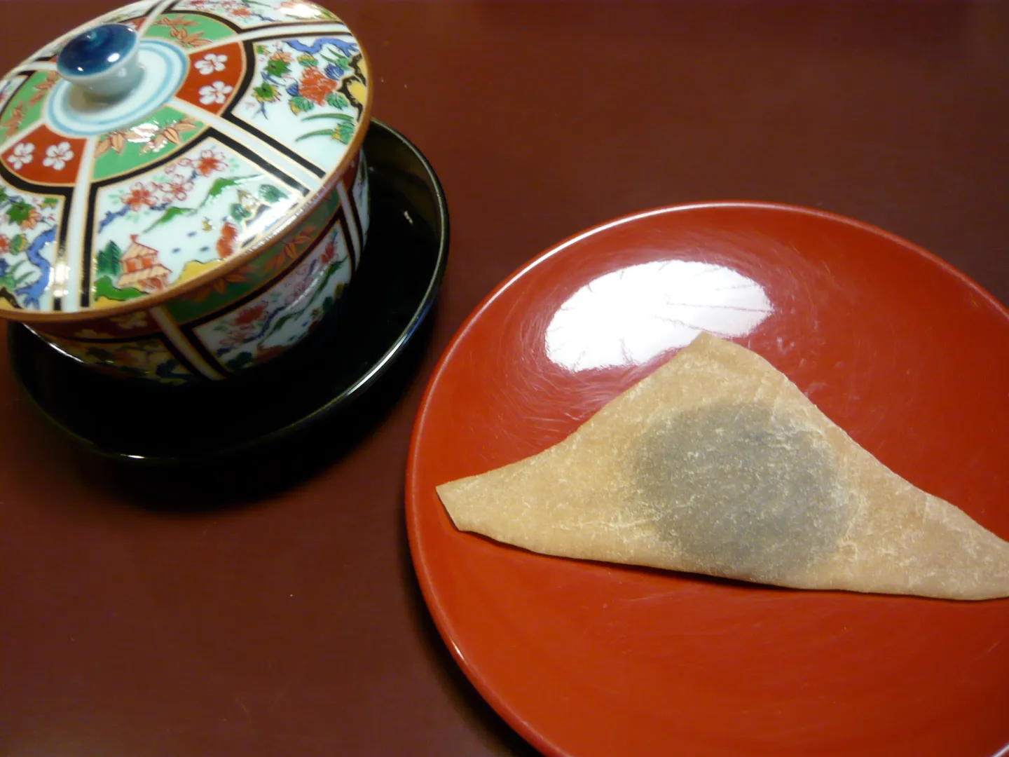 A triangular yatsuhashi sweet served with tea.