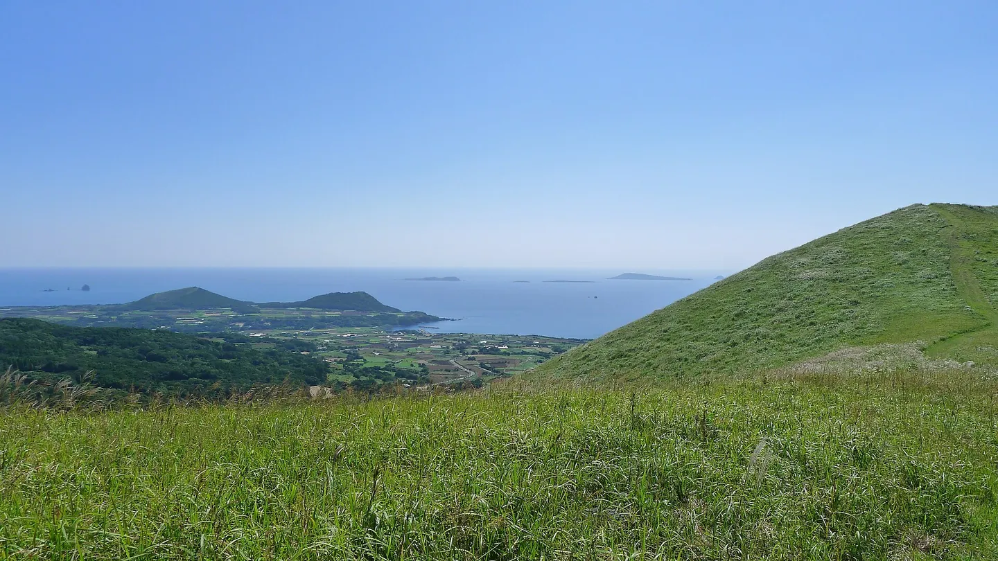 Grassy slopes and the sea viewed from Onidake on Fukue Island.