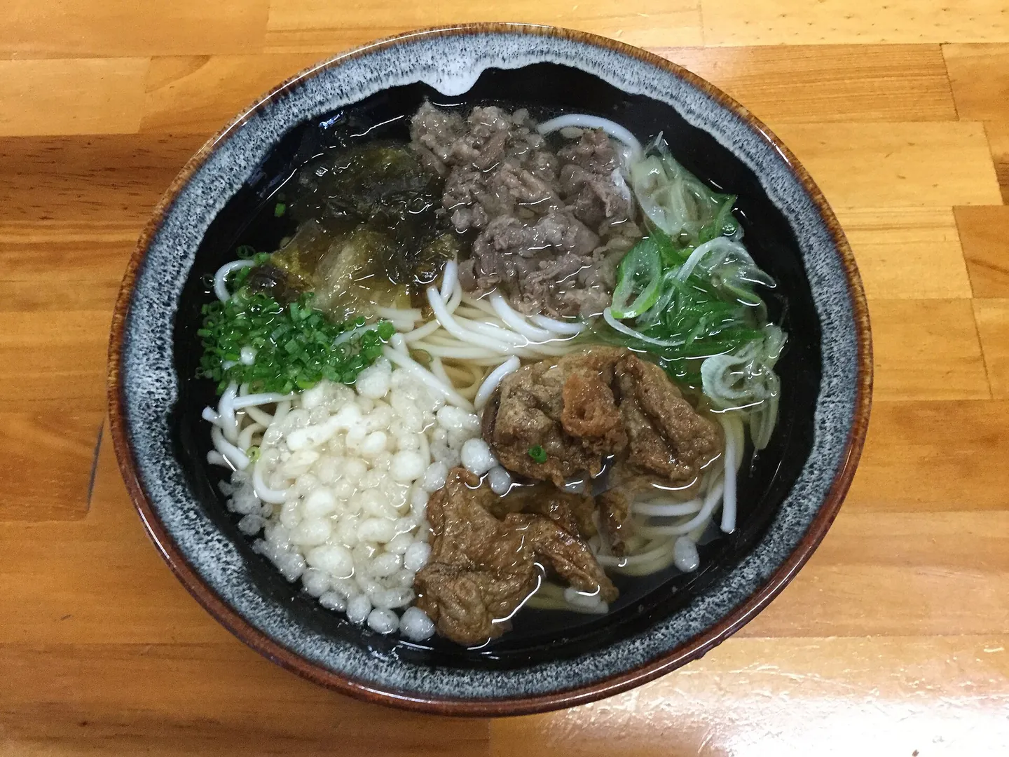 A bowl of Goto udon with toppings in a public travel photograph.