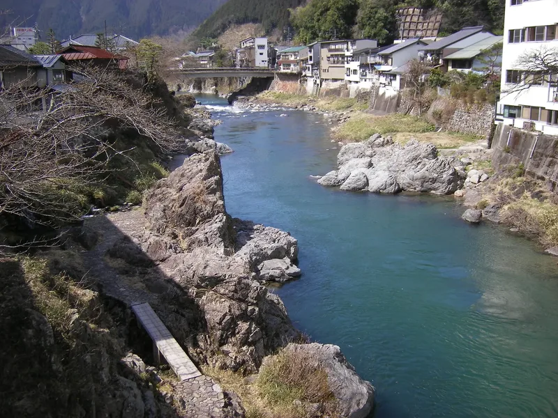 The Yoshida River flowing between houses and rocky banks in Gujo Hachiman.