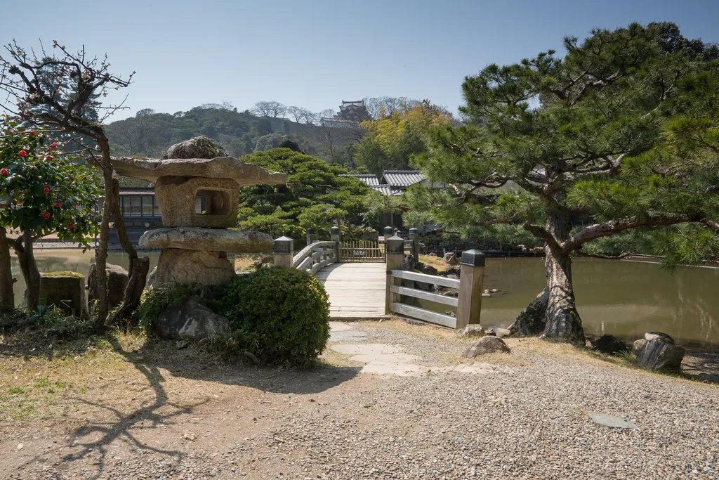 En stenlanterne og bro i Genkyuen-haven i Hikone.