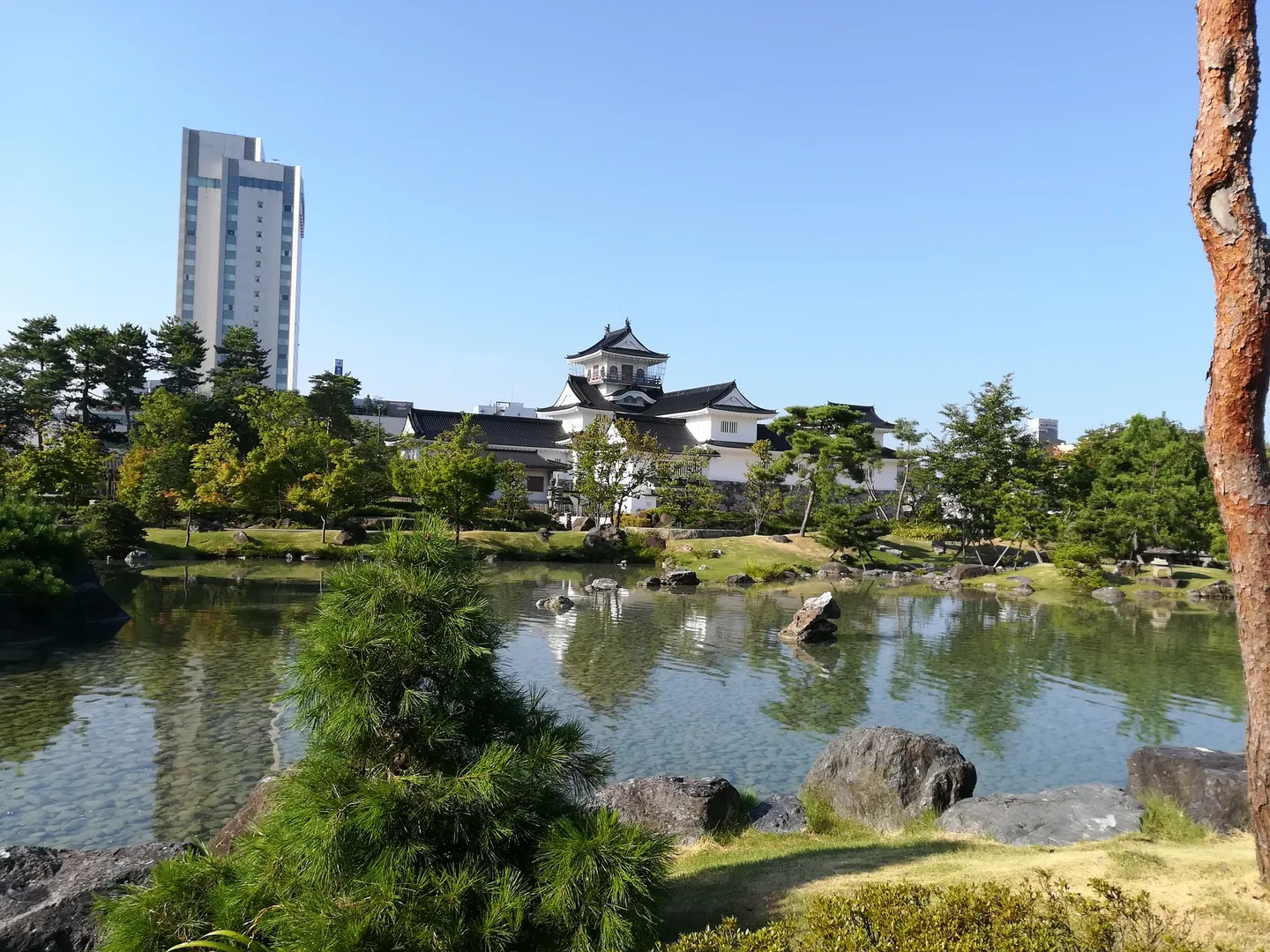 Castillo Toyama reflejado en el estanque en su parque.