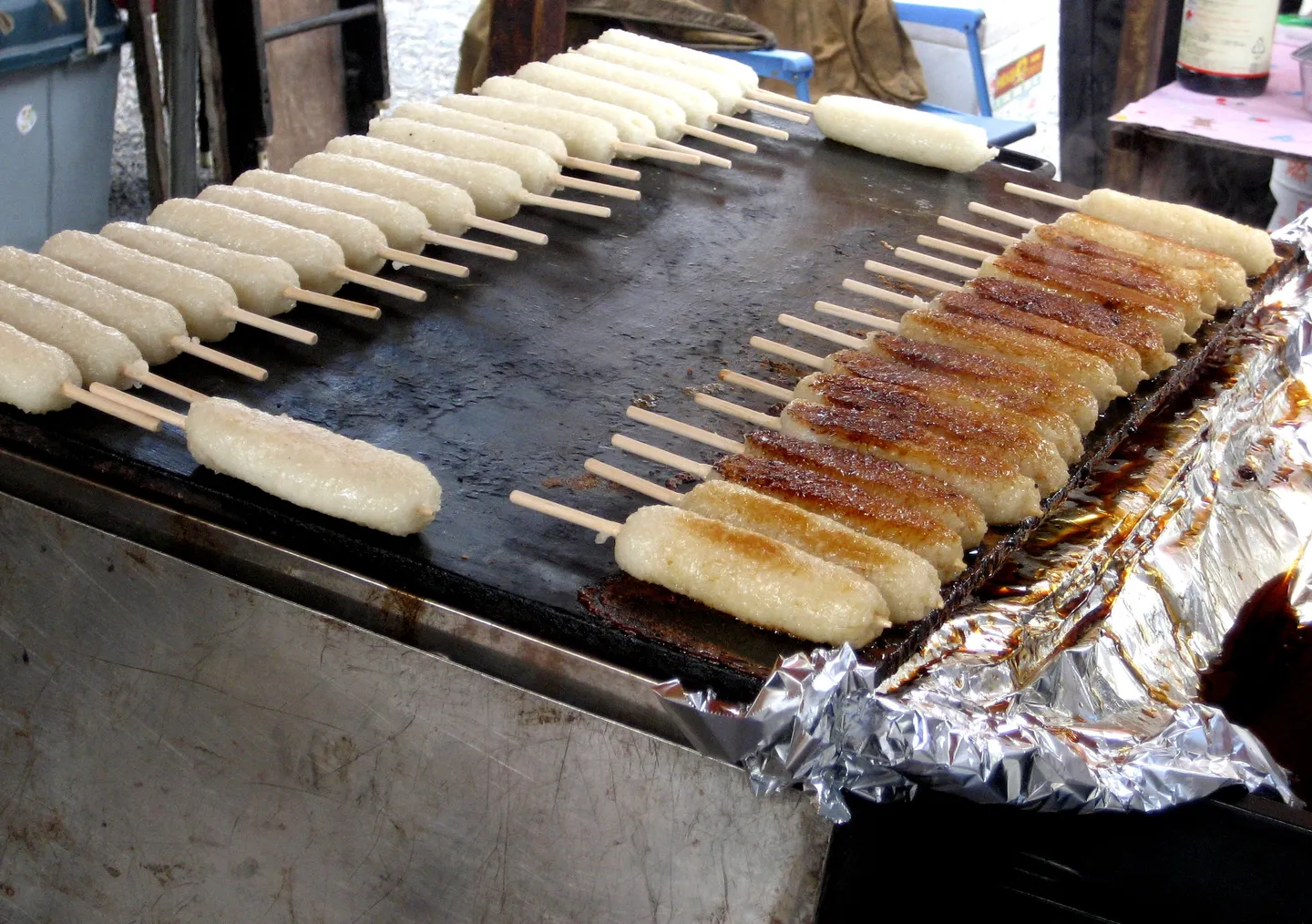Gohei mochi skewers Kochen auf einem Grill; ein illustratives regionales Lebensmittel Foto.