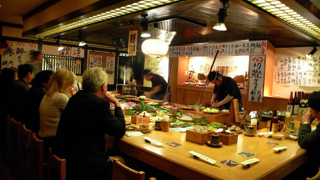 Zákazníci sedí u pultu restaurace v Tokiu.
