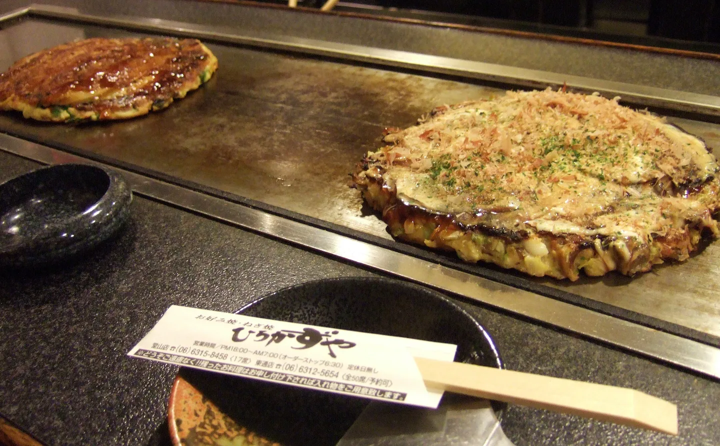 Okonomiyaki cooking on a griddle in Osaka.