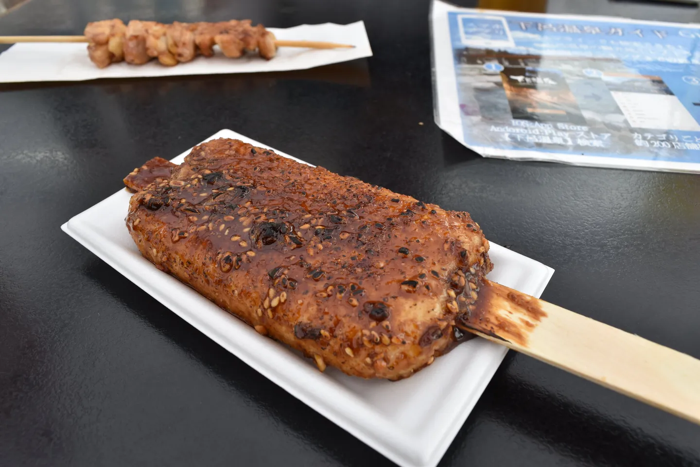 Grilled gohei mochi on a skewer, illustrating a regional speciality.