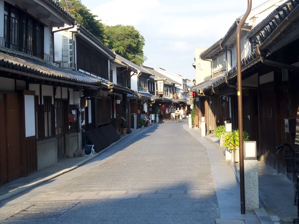 A historic street with timber facades in Kurashiki's Bikan district.