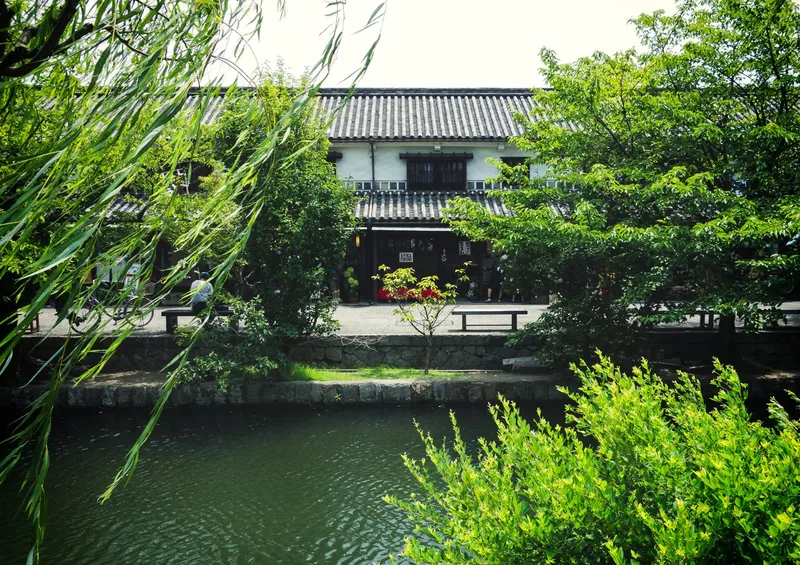 The canal of the historic Bikan district in Kurashiki, between willows and traditional buildings.