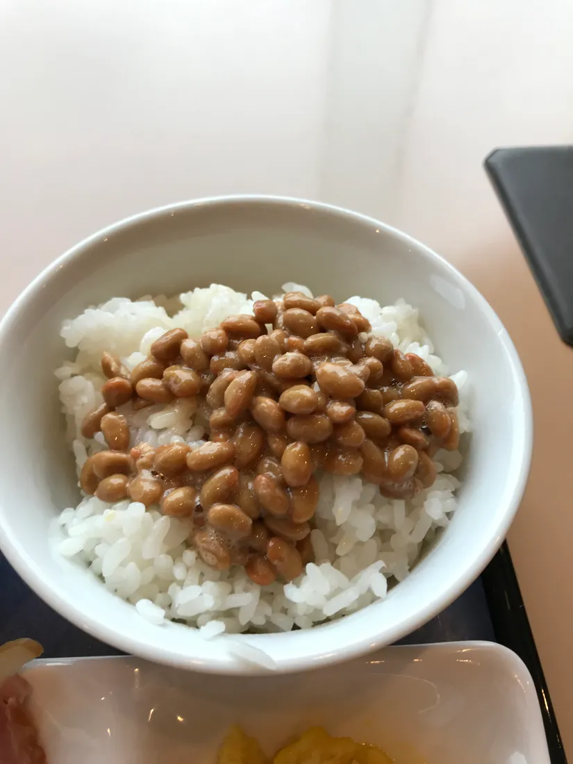 Natto, fermenterede sojabønner, serveret med ris; et illustrativt madfotografi.