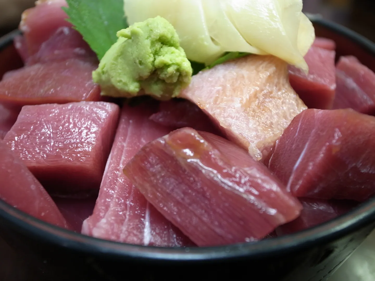 Maguro-don: tonfisk över ris med wasabi och inlagd ingefära; ett illustrativ matfoto.
