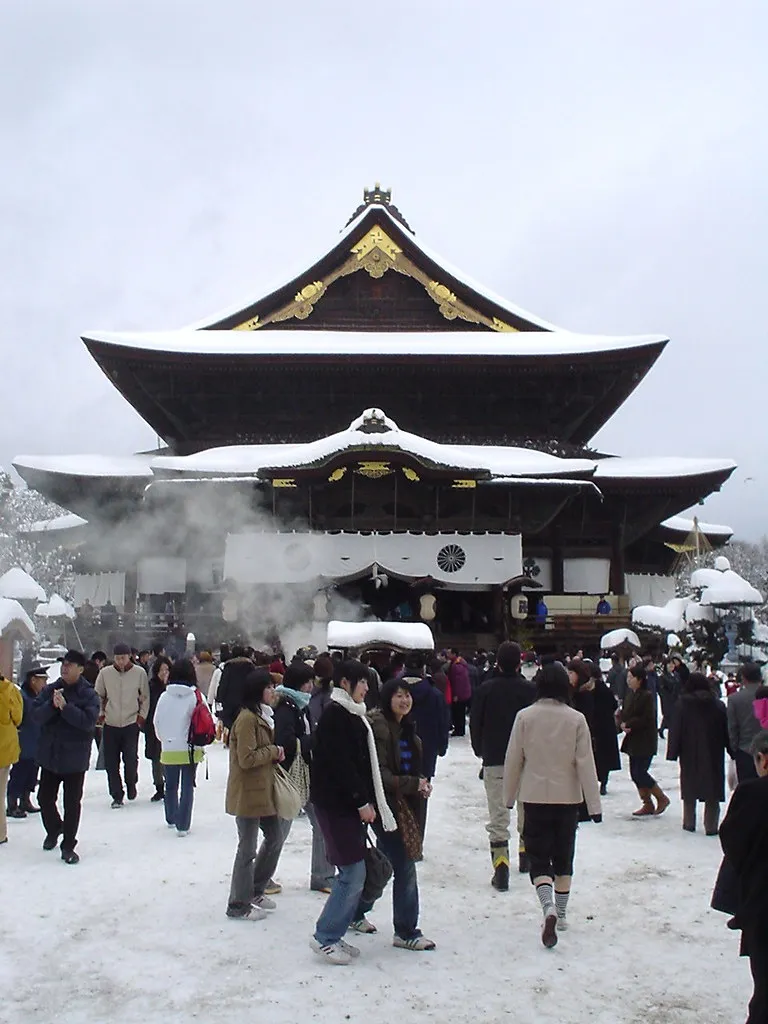 Besucher im Schnee vor dem Zenkoji Tempel in Nagano.