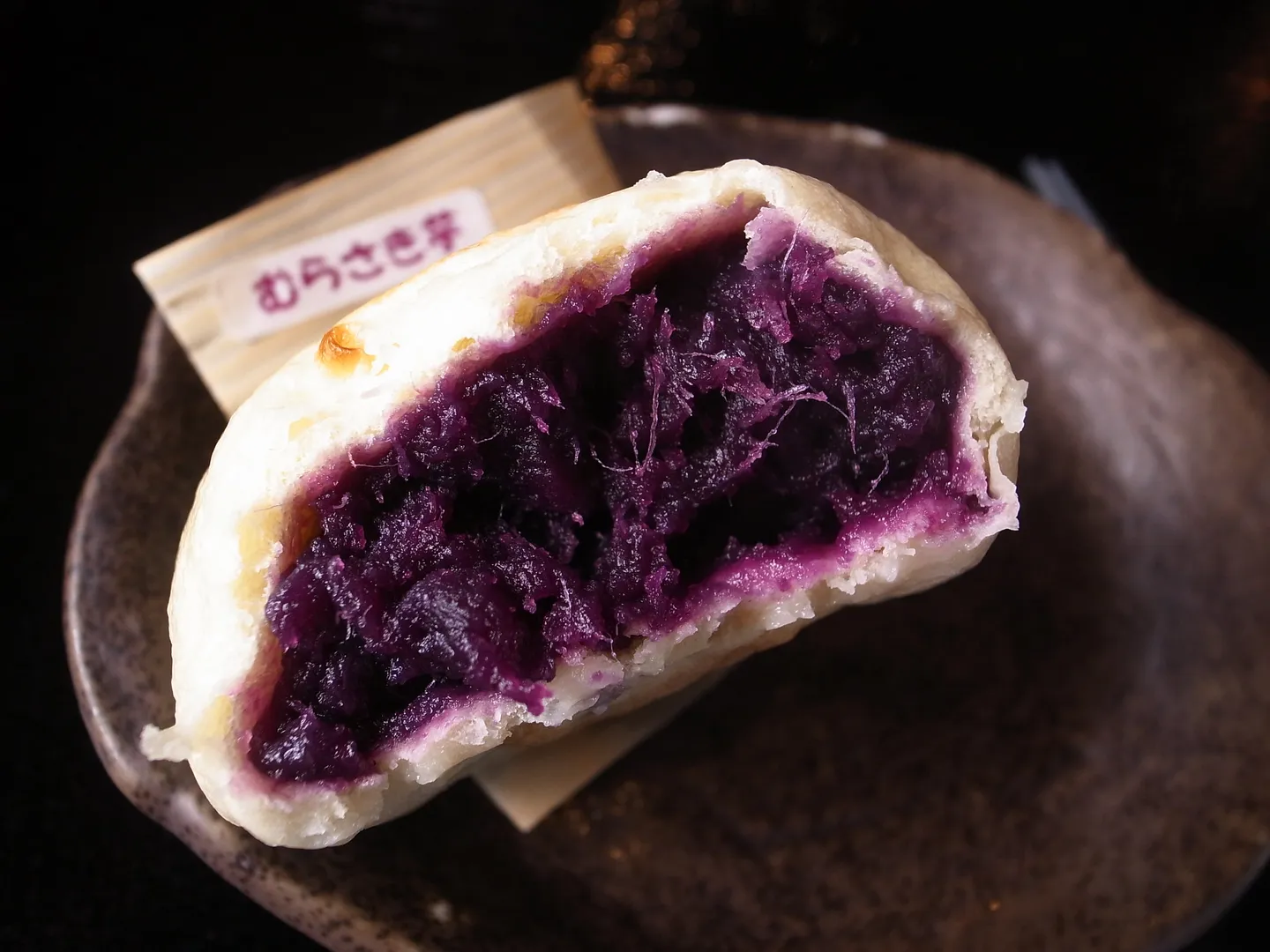Ein Oyaki Brötchen mit lila Füllung, eine Shinshu Spezialität illustrierend.
