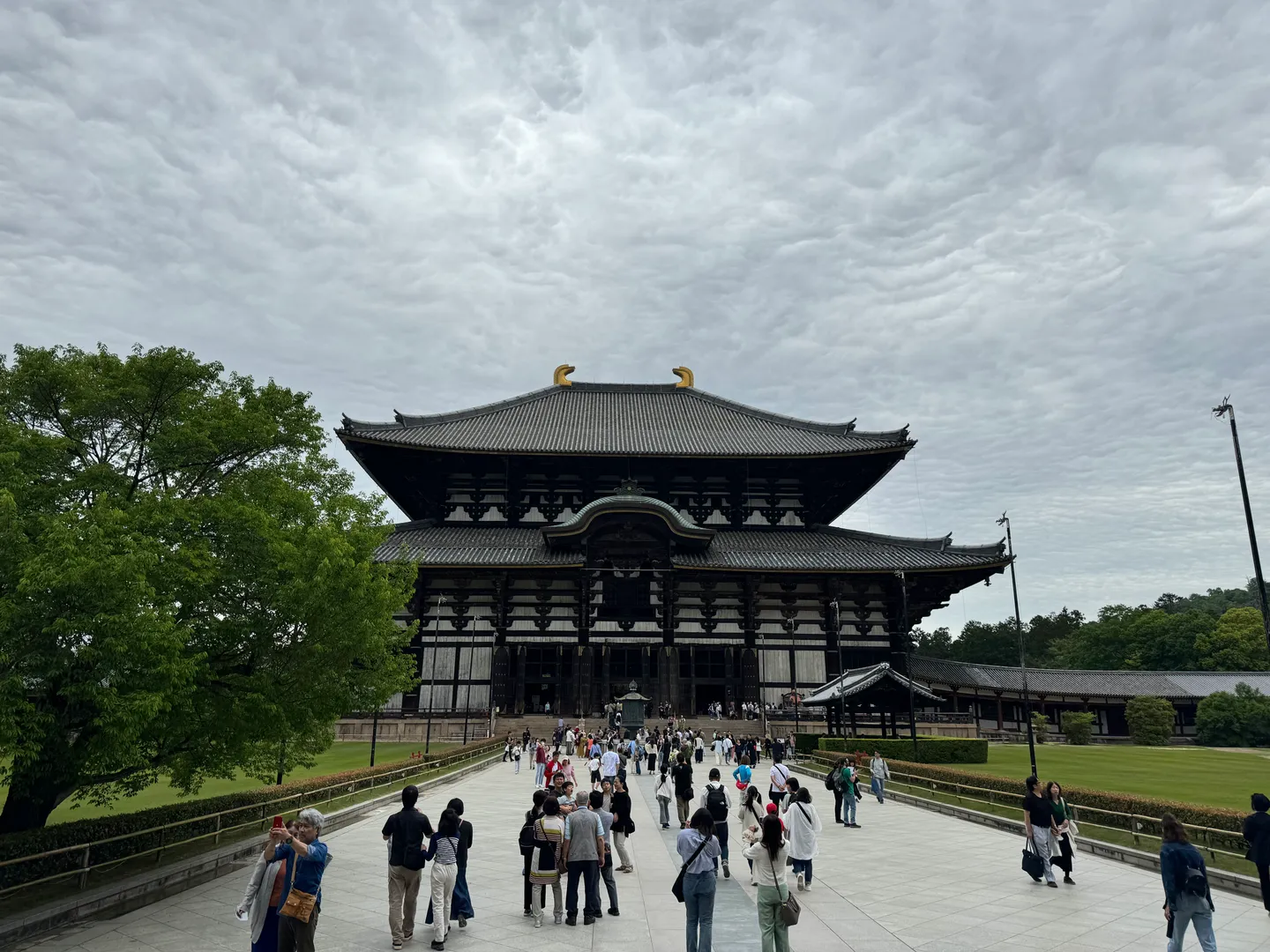 Des visiteurs devant un bâtiment en bois du Tōdaiji à Nara.