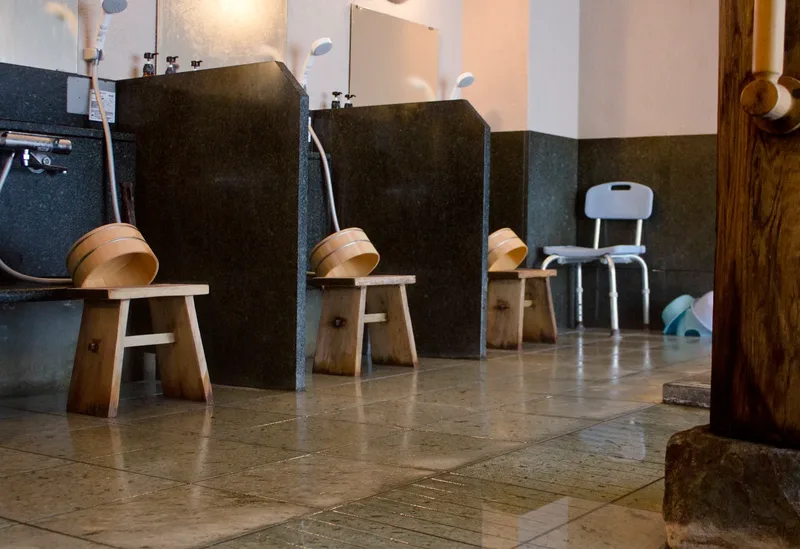 Washing stations with stools, buckets and handheld showers at an onsen in Nagahama.