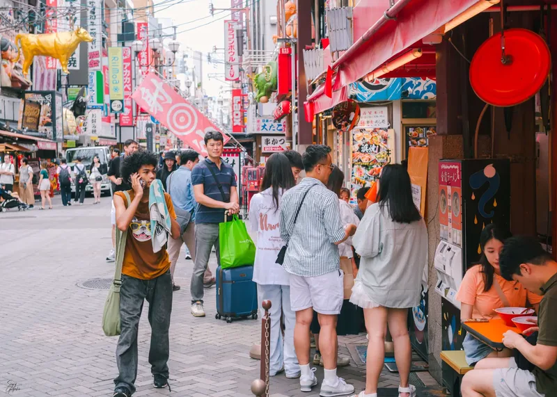 Visitors on a shopping street in Dotonbori, Osaka, during the day.