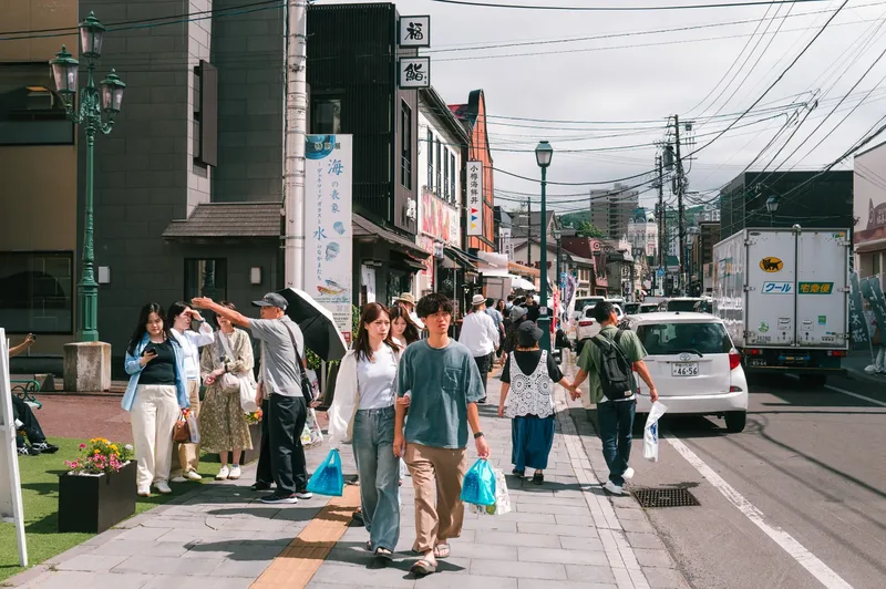 Visitors walking along a shopping street in Otaru, Hokkaido.