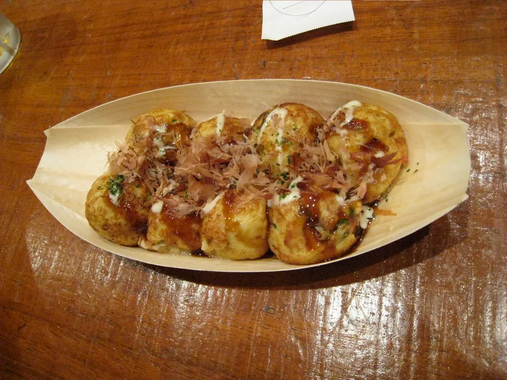 Takoyaki Krake Knödel serviert in einem Boot-förmigen Tablett.