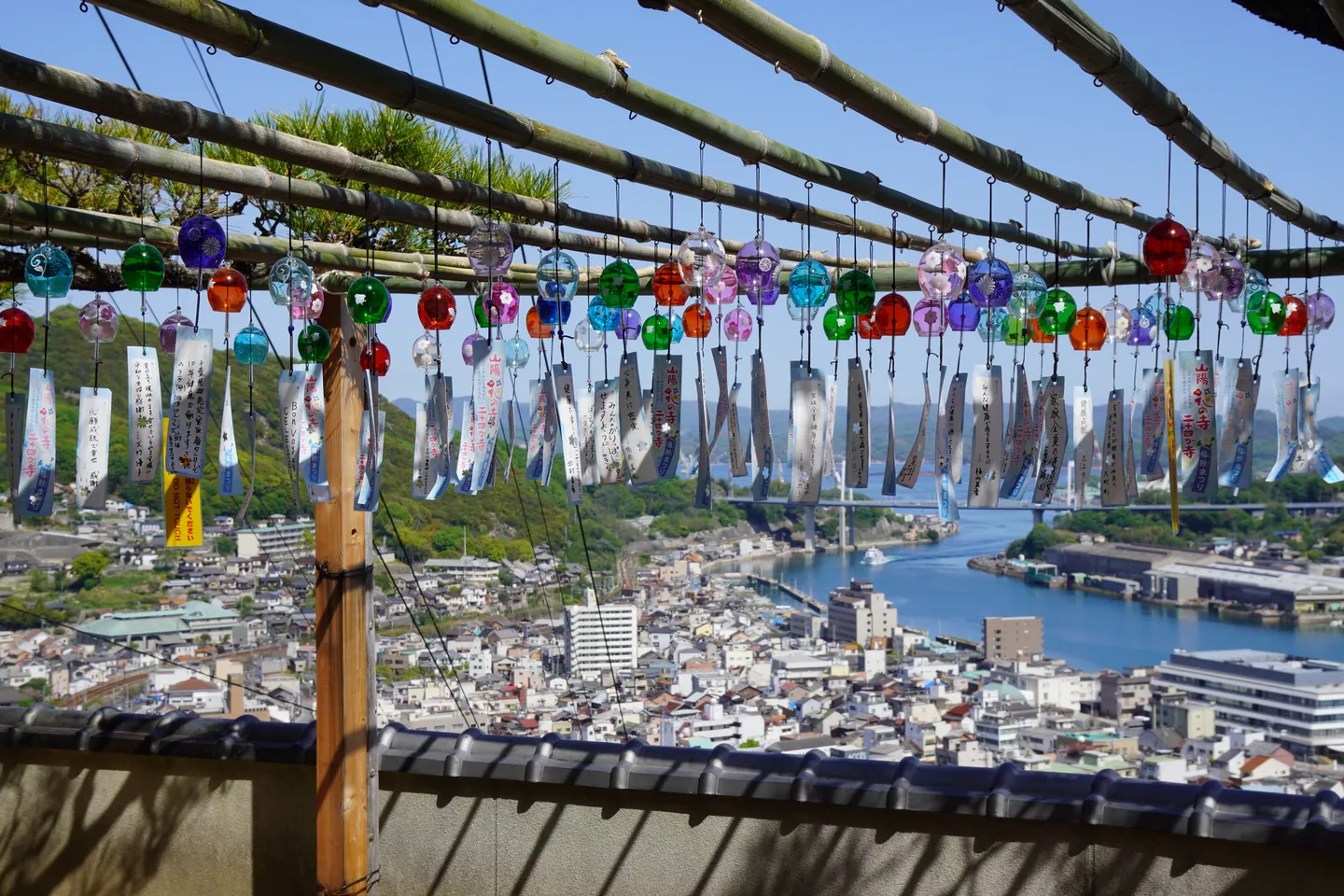 Onomichi og Seto-innsjøen sett fra åssiden, bak hengende dekorasjoner.