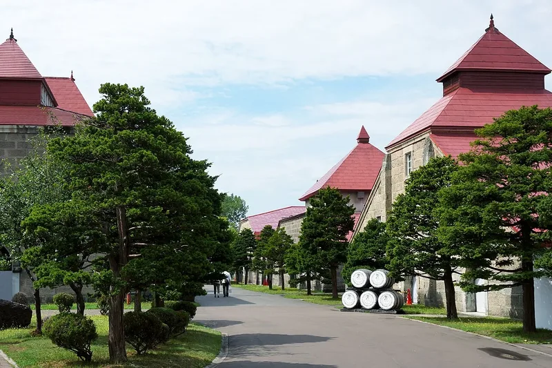 Red-roofed stone buildings along an avenue at Nikka Yoichi Distillery.