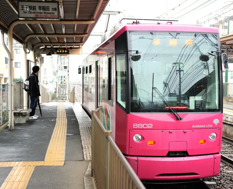 A pink tram at a stop on Tokyo’s Arakawa Line