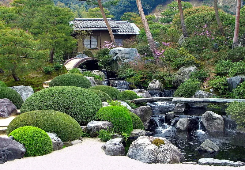 A waterfall and shaped shrubs in the Adachi Museum garden