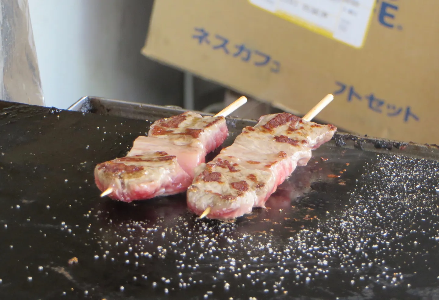 Hida-Rindfleischspieße auf einer Grillplatte in Takayama: regionale Küche nahe Shirakawa-go.