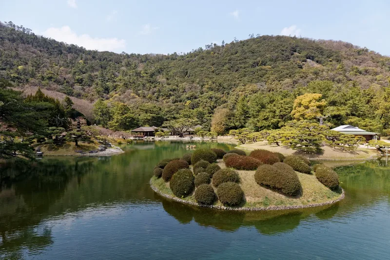 A pond, pine trees and wooded hills at Ritsurin Garden in Takamatsu.
