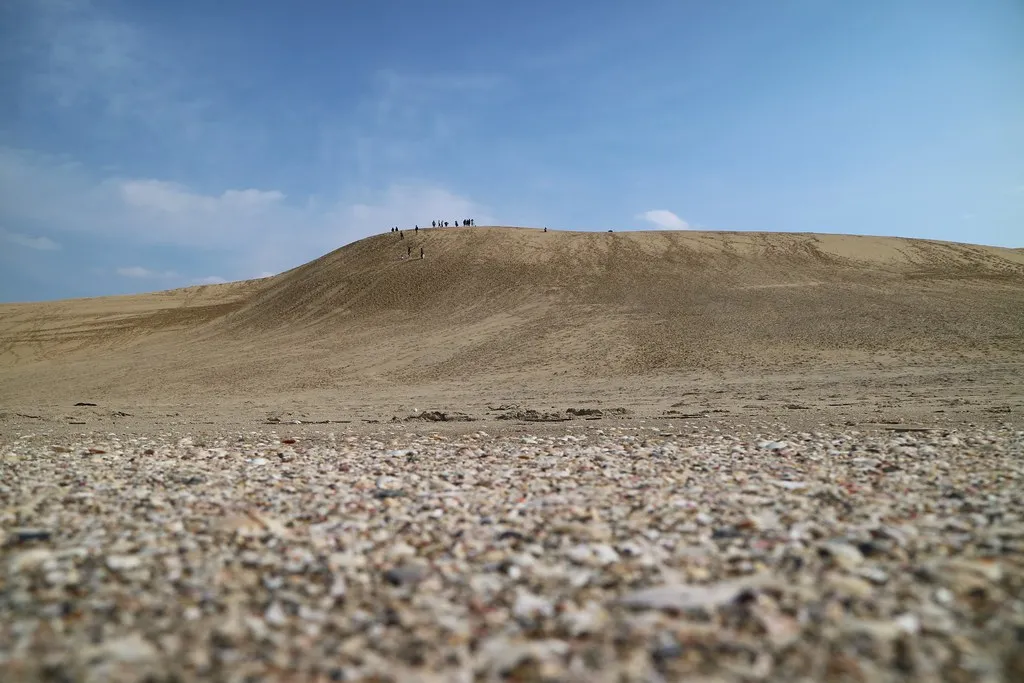 Piasek na pierwszym planie i grzbiet wydm Tottori.