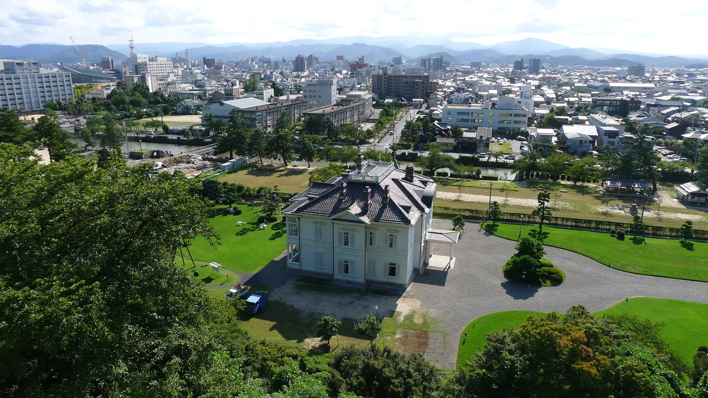 Tottori widziane z terenu zamku z białym budynkiem i ogrodami.