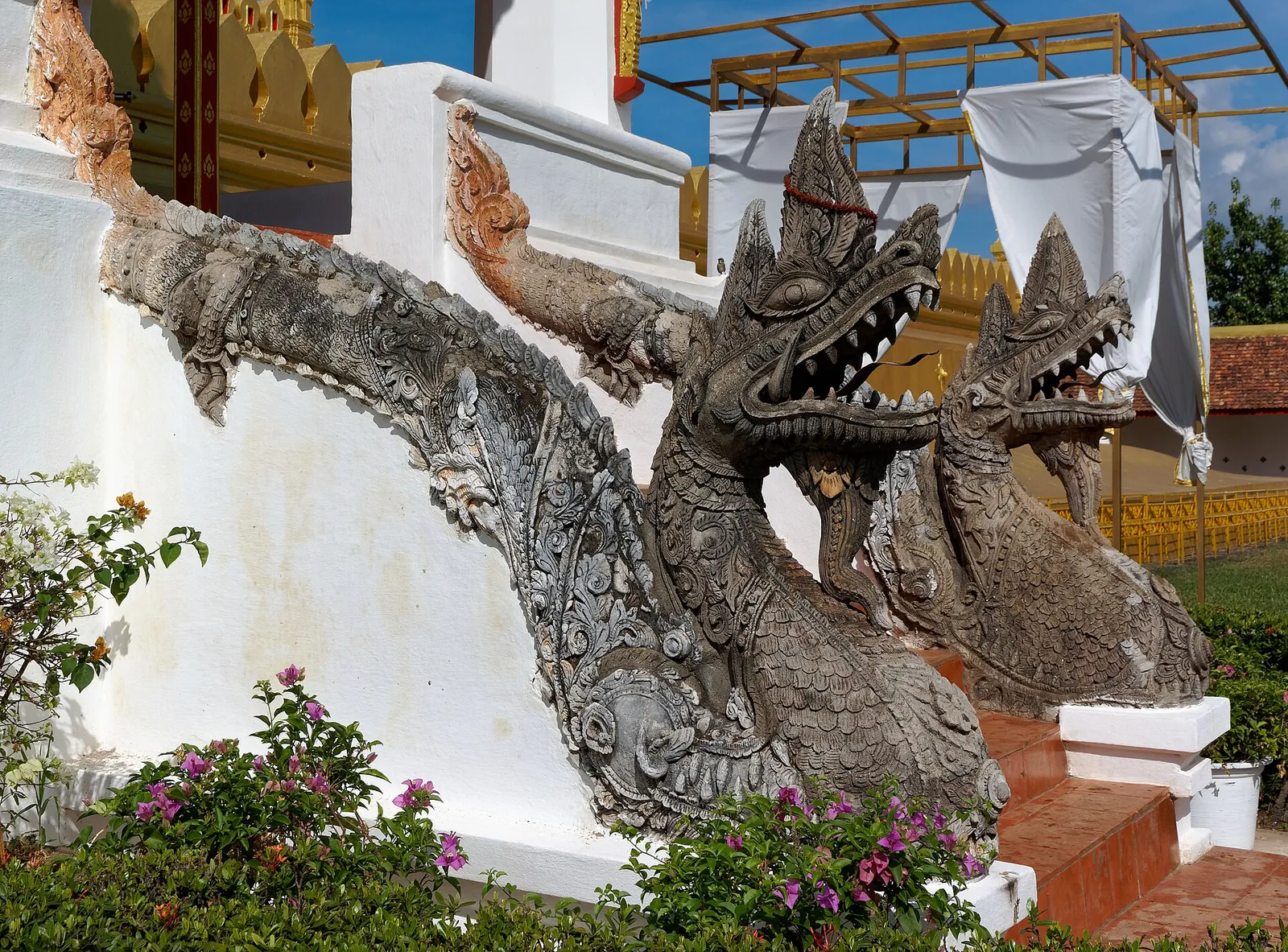 Escultura de naga junto a unas escaleras de Pha That Luang