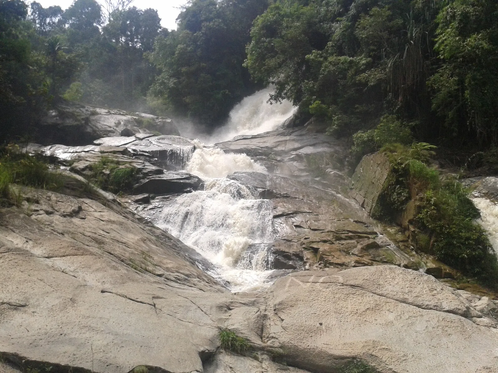 Water cascading over broad rock slabs at Chamang waterfall near Bentong