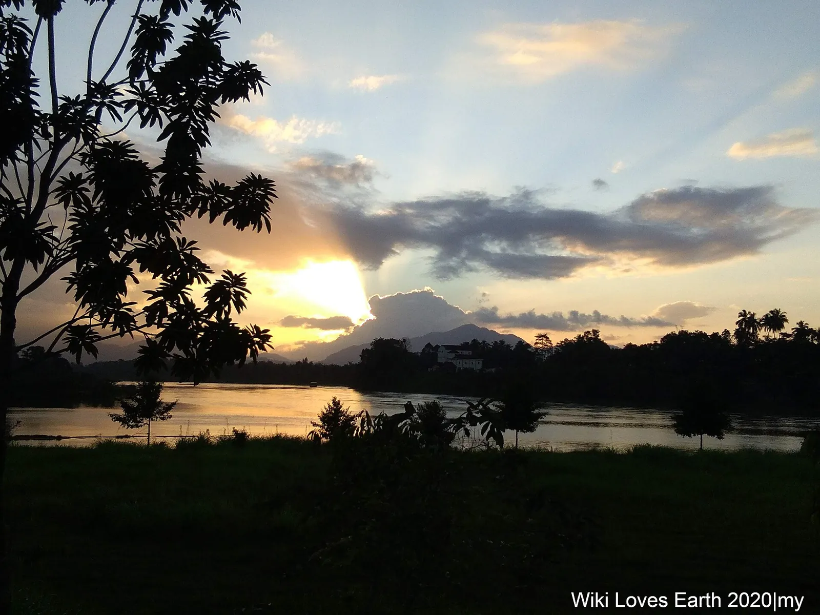 Sunset reflected in Sungai Berang beside trees in Kuala Berang