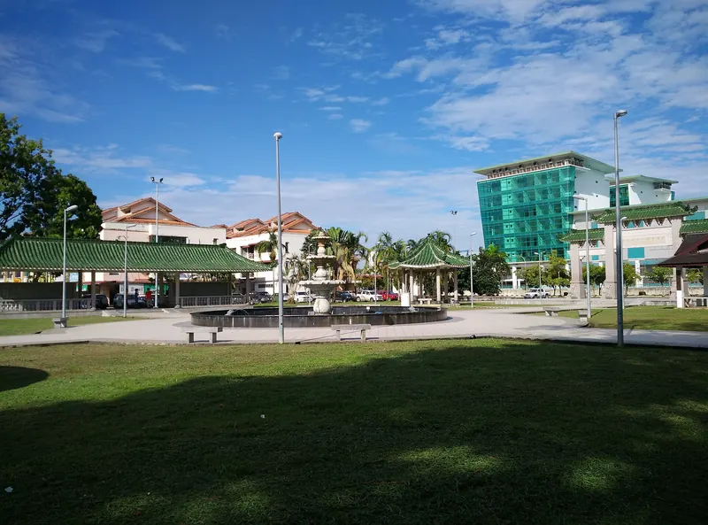 Landscaped green space and buildings in Bintulu under a blue sky
