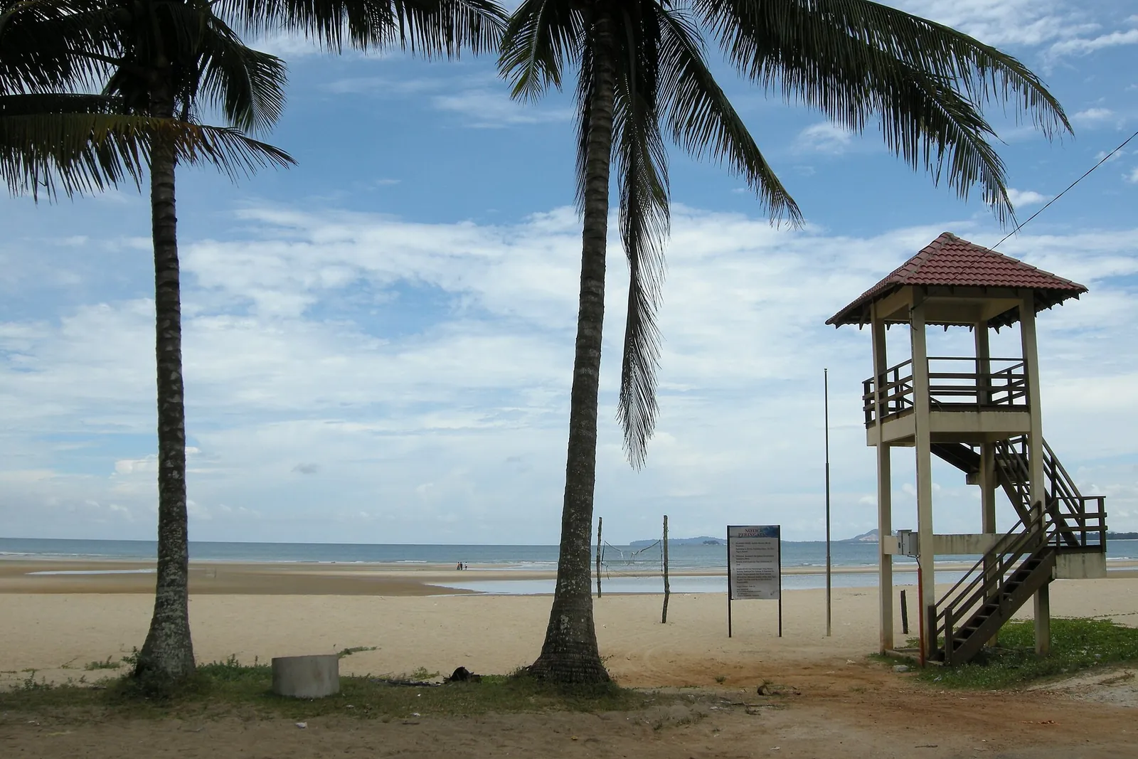 Palm trees and a wooden lookout beside Cherating Beach