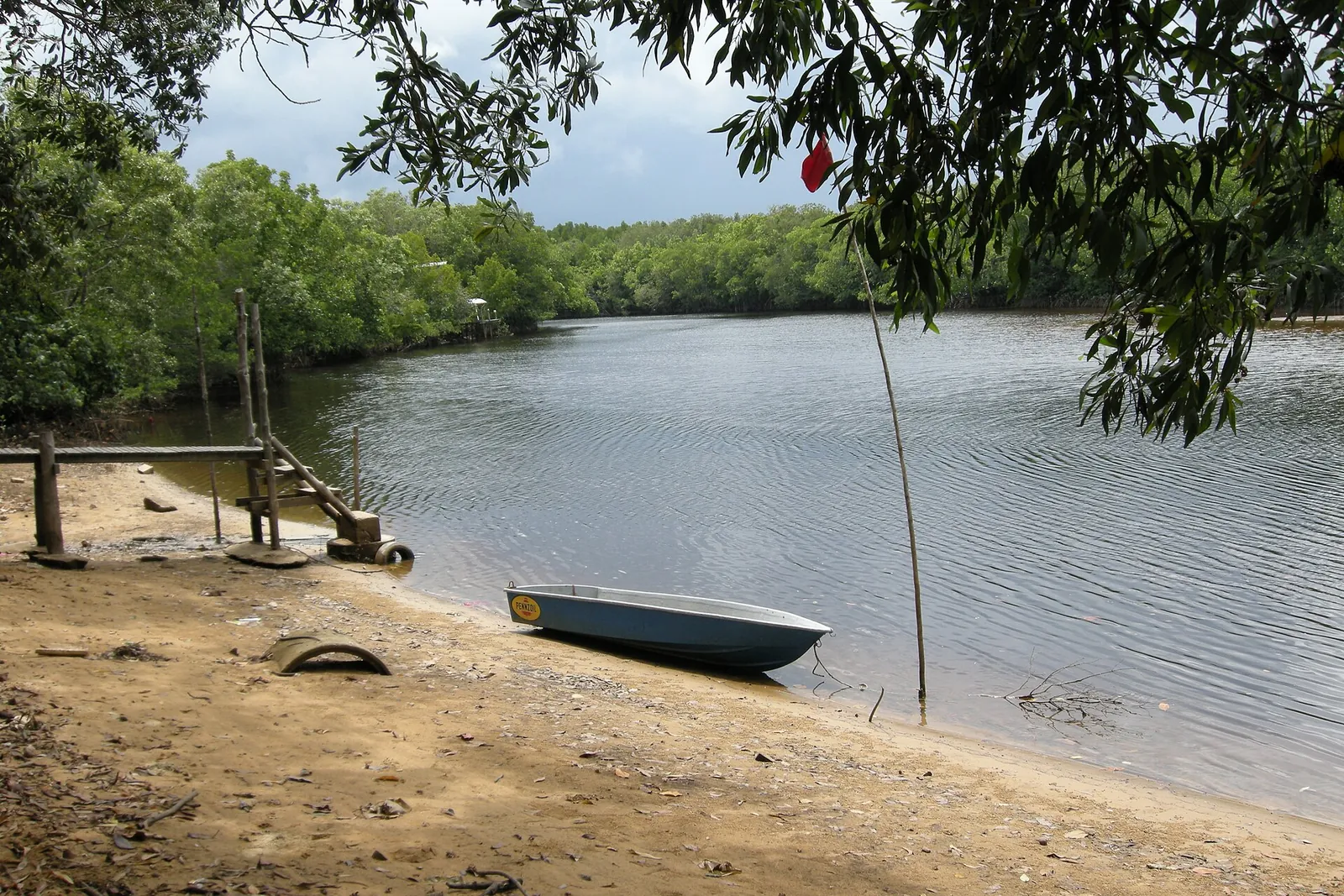 Small boat and sandy bank beside a lagoon at Cherating