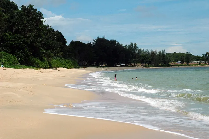Sunlit sandy beach and gentle shoreline at Desaru in Johor