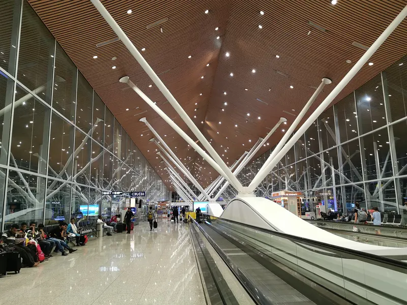 Long travelator under the white steel ribs and wooden ceiling of Kuala Lumpur International Airport